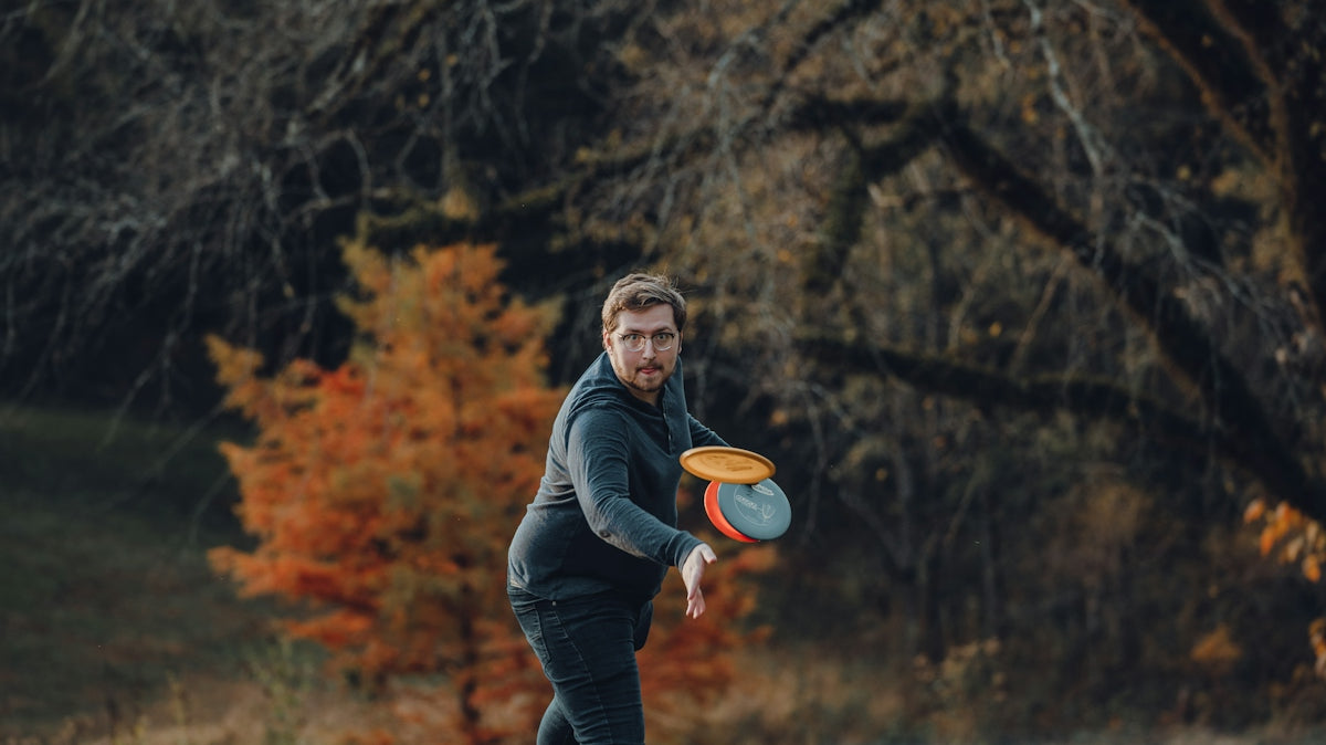 a man is throwing a frisbee in a field