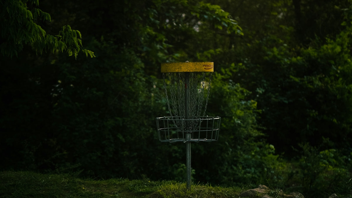 a frisbee golf goal in the middle of a field