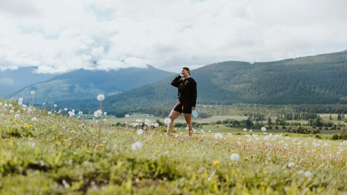 a man standing on top of a lush green hillside