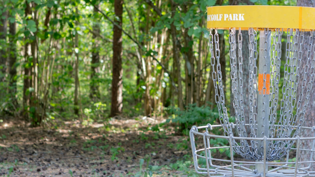 a frisbee golf cage in a wooded area