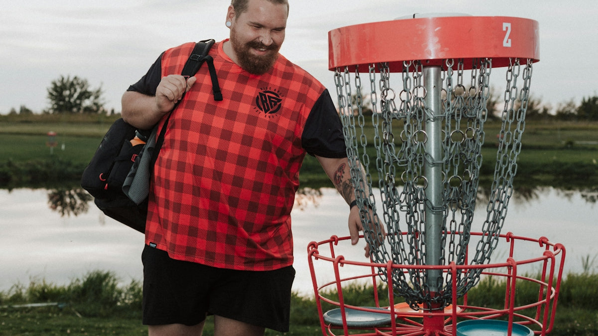 A man standing next to a frisbee golf net