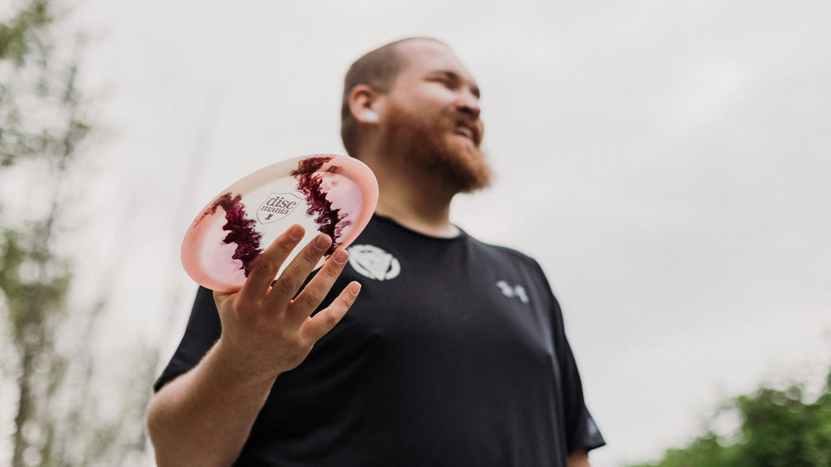 Man holding a disc golf disc outdoors