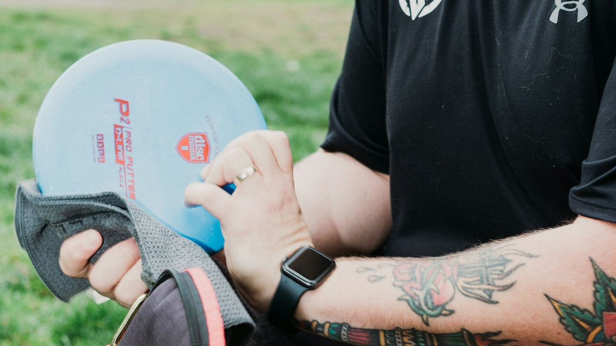 Man with beard and tattoos holding a disc golf disc