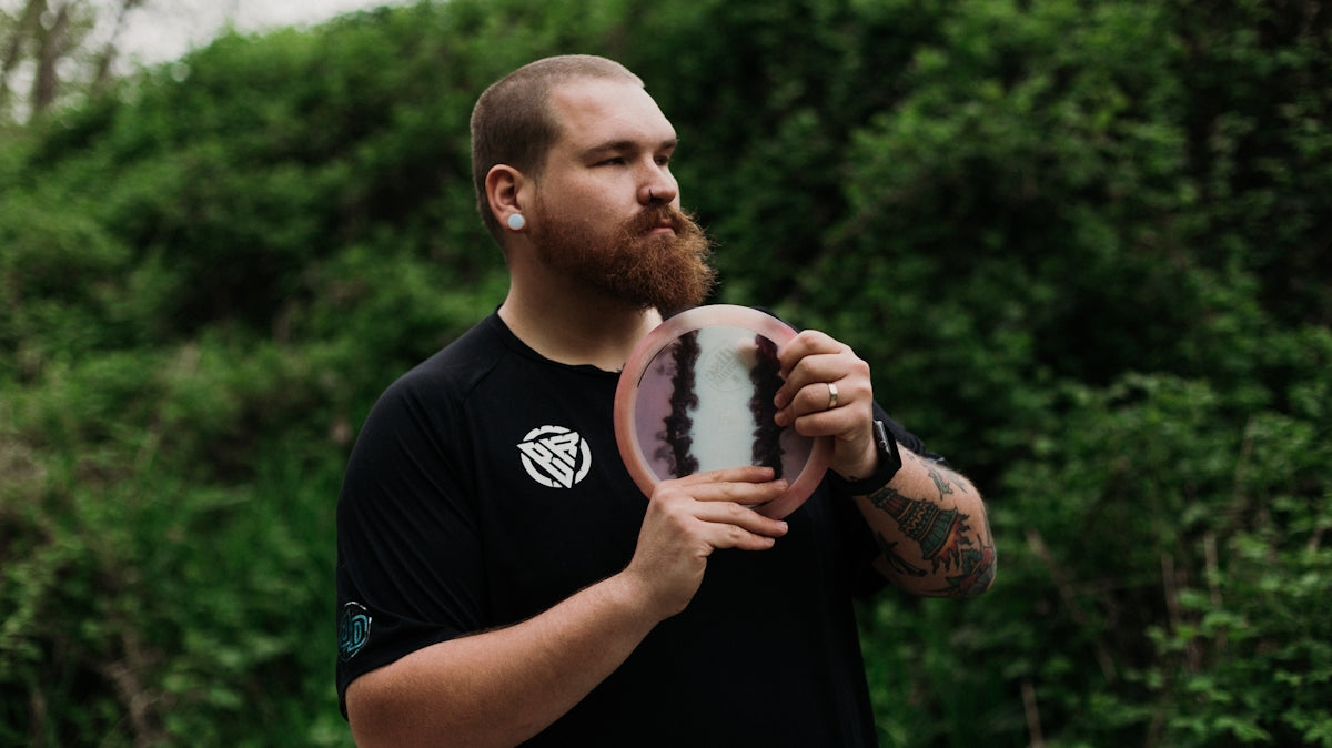 Man holding a disc golf disc outdoors