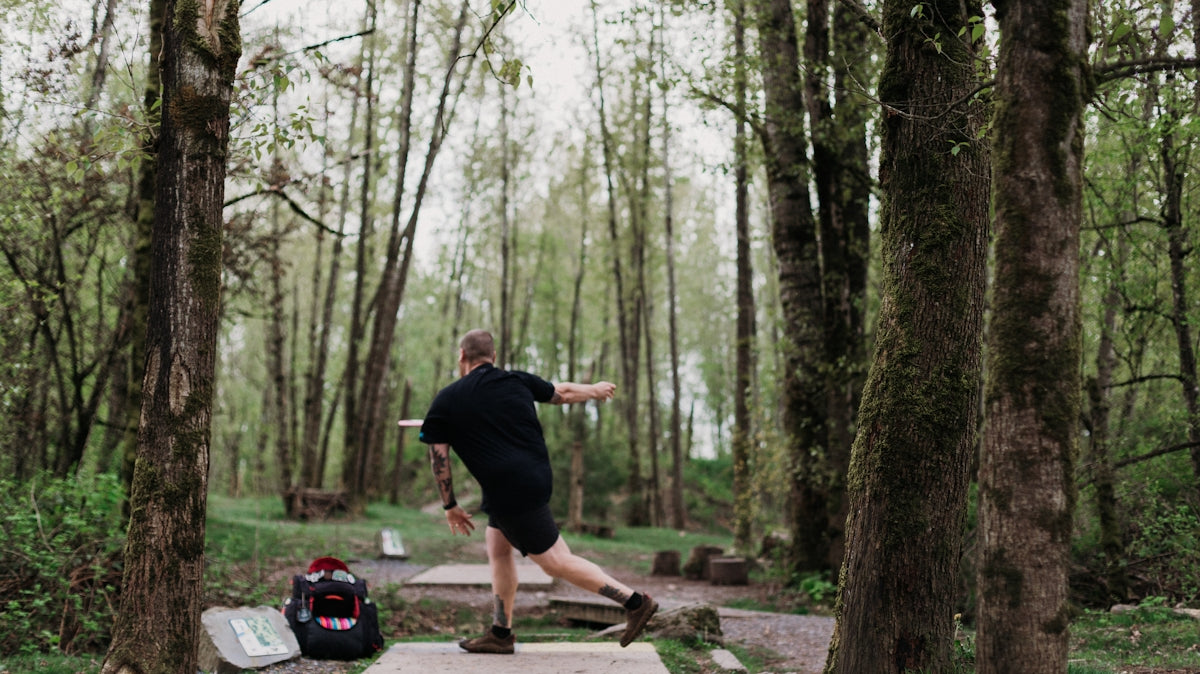 Man playing disc golf in a forest