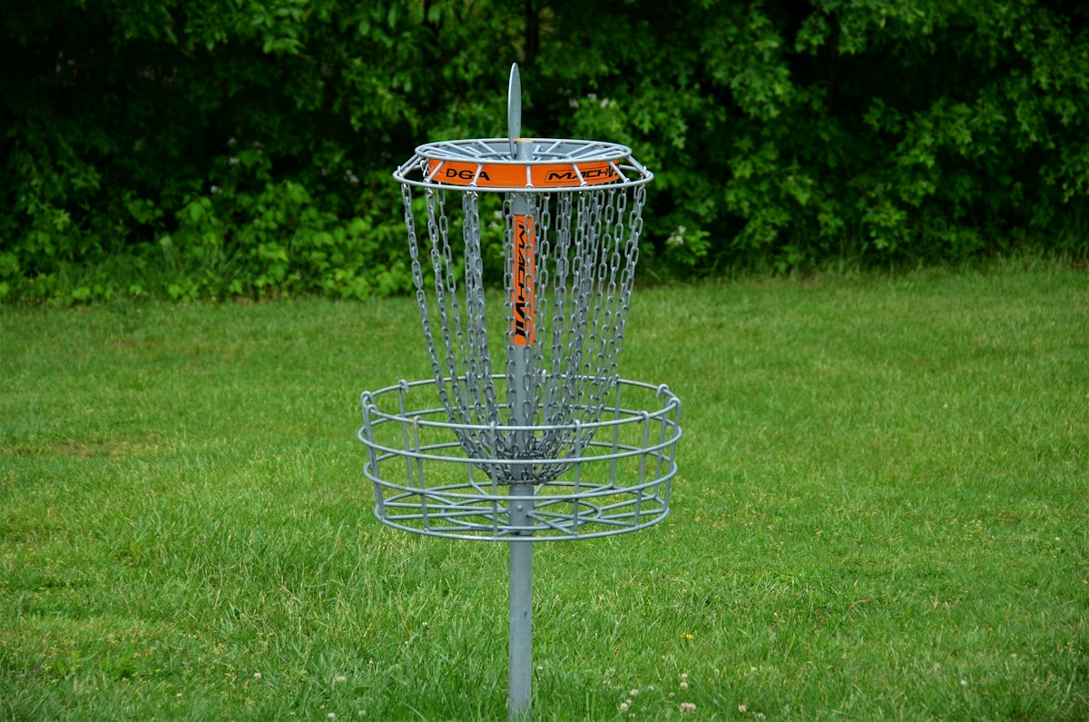 a frisbee golf cage in the middle of a field