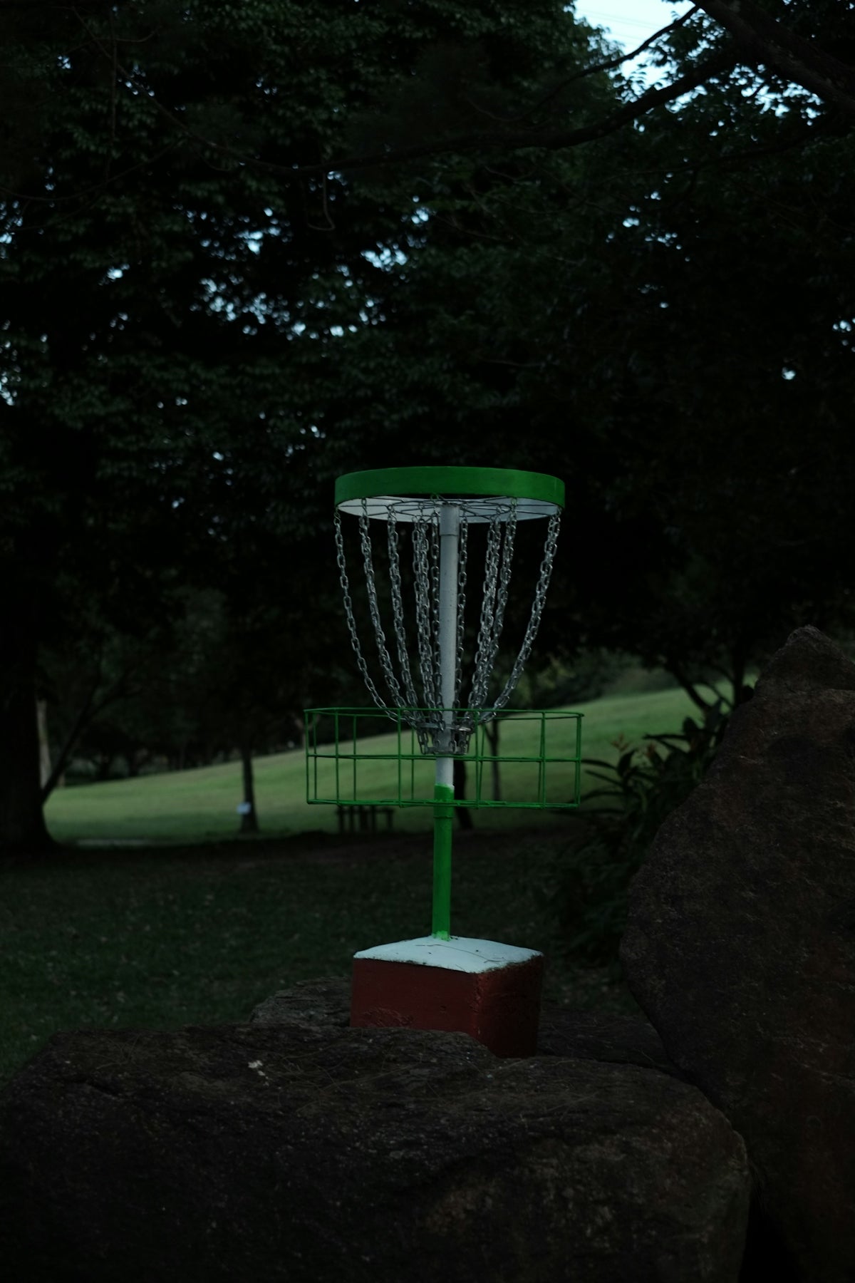 a green and white frisbee is in the air