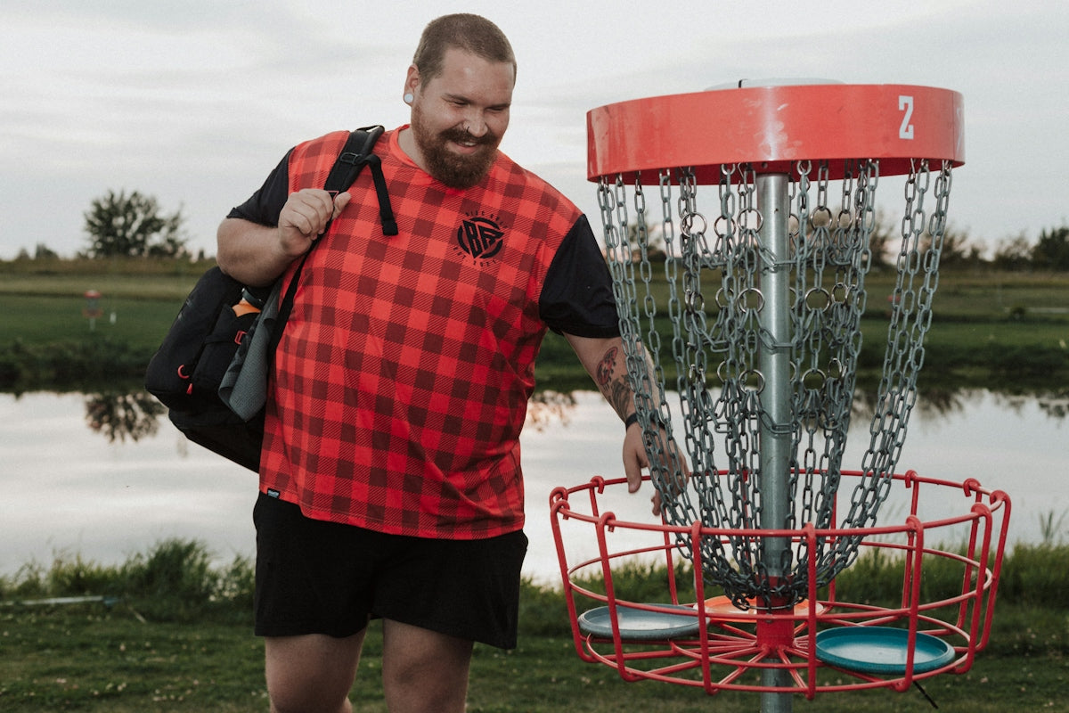 A man standing next to a frisbee golf net