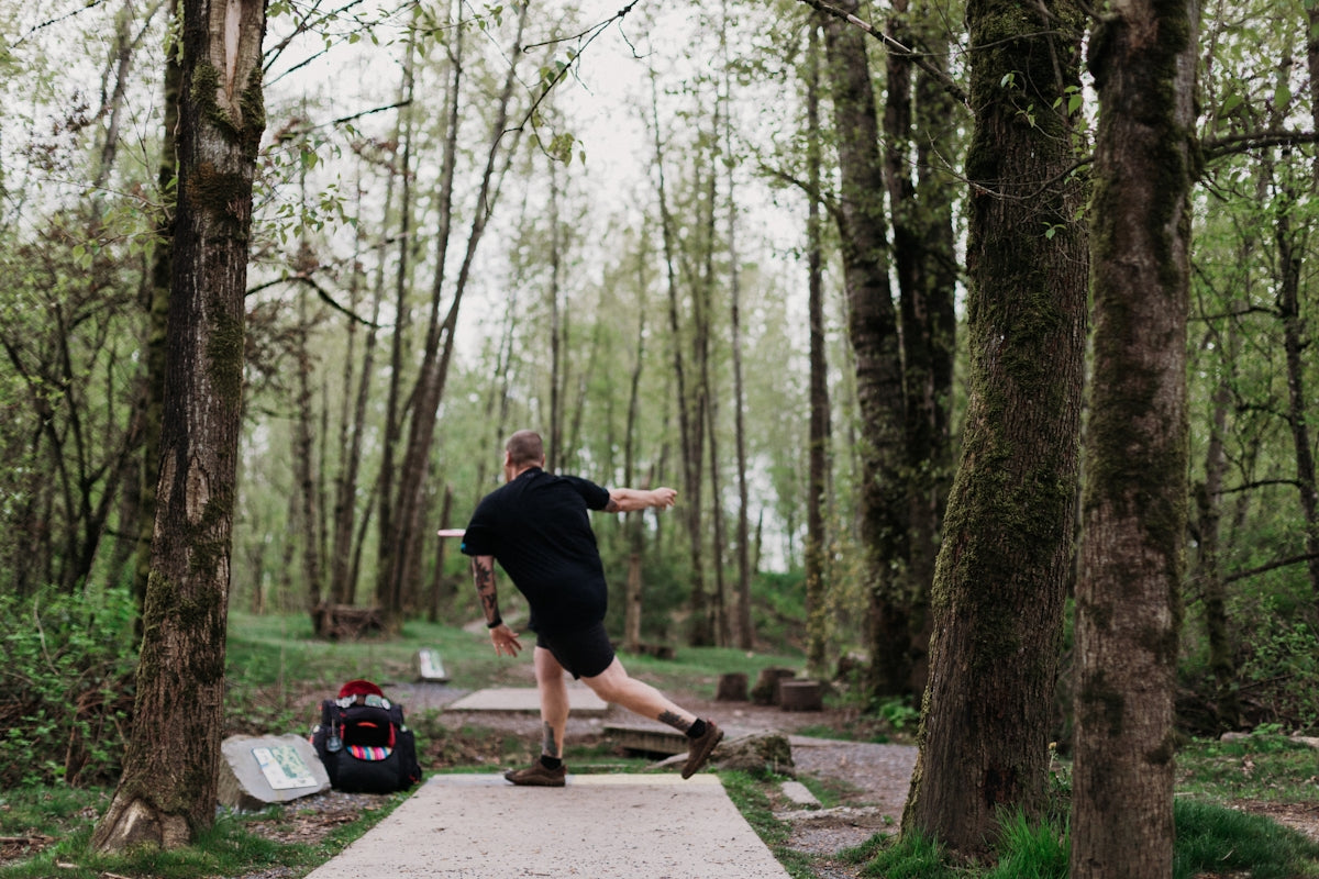Man playing disc golf in a forest